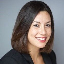Smiling woman with shoulder-length brown hair wearing a black blazer.