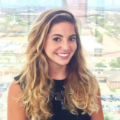 Woman smiling in an office with cityscape view.