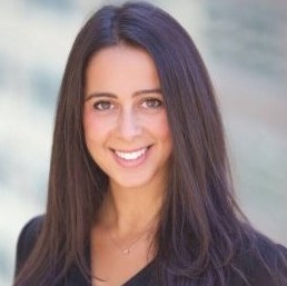 Smiling woman with long brown hair wearing a black top.