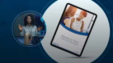 Woman speaking at a tech event with a tablet displaying 'Women in Tech' cover.
