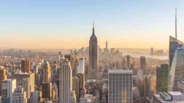 Skyline of New York City at sunset with the Empire State Building in view.