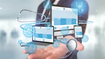 Hand holding digital medical interface with a stethoscope and health icons.