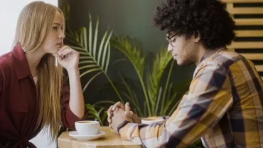 Two people deep in conversation at a cafe table.