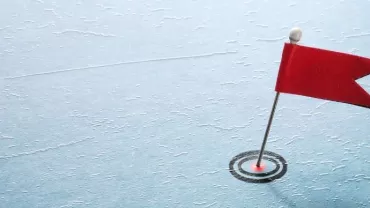 A red flag pin on a textured blue surface resembling ice.