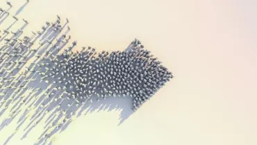 A group of people forming a large arrow on a light background, viewed from above.