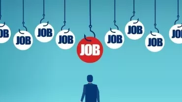 Silhouette of person looking at hanging 'job' signs with one highlighted in red.