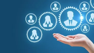 Hand reaching towards network of gear icons with silhouettes on blue background
