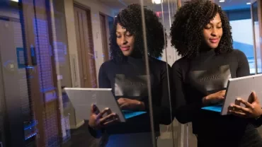 Woman using a tablet in a data center hallway.