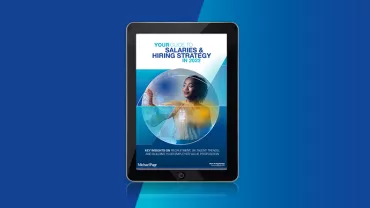 E-book on a tablet about salaries and hiring strategy for 2023.