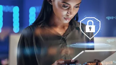 Woman using a tablet with a digital padlock icon overhead.