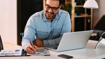 Man sitting on a desk with his laptop