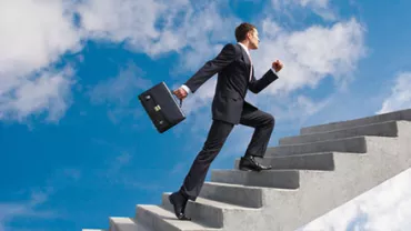 Man in a suit climbing stairs into the sky with a briefcase.