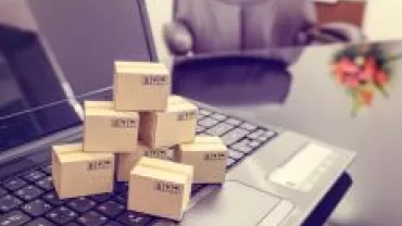 Small cardboard boxes on a laptop in an office setting.
