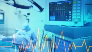 Hospital operating room with patient and heart monitor.