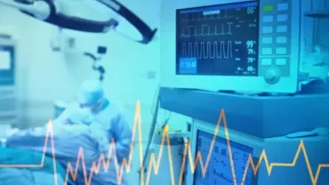 Hospital operating room with patient and heart monitor.