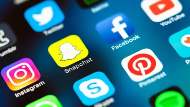 Close-up of various social media app icons on a smartphone screen.