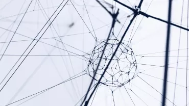 Close-up of a geometric wire structure with intersecting lines on a light background.