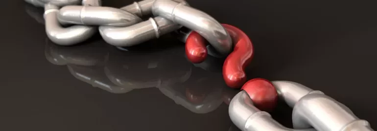 Close-up of a metallic chain with a red link standing out.