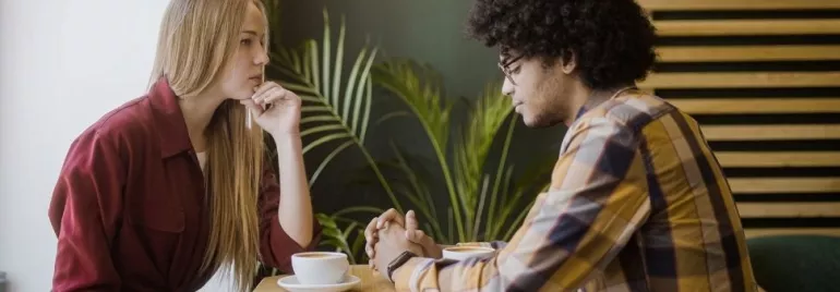 Two people deep in conversation at a cafe table.