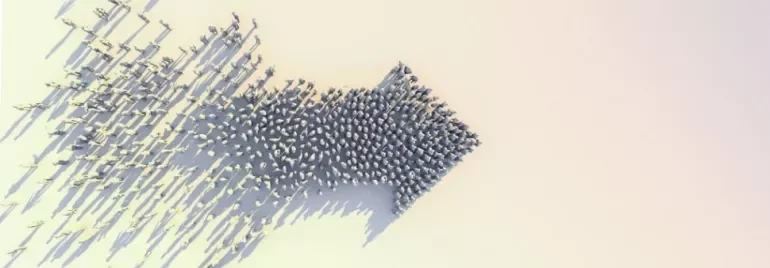 A group of people forming a large arrow on a light background, viewed from above.