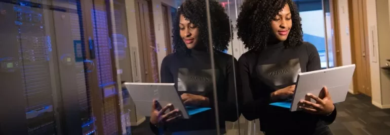 Woman using a tablet in a data center hallway.