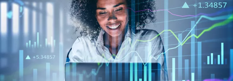 Smiling woman at a laptop with digital finance graphs overlayed.