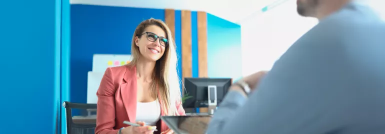 Smiling woman in glasses having a meeting in a bright office.