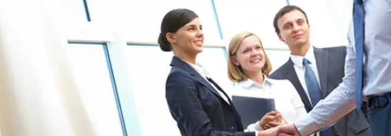 Group of business people shaking hands in a modern office.