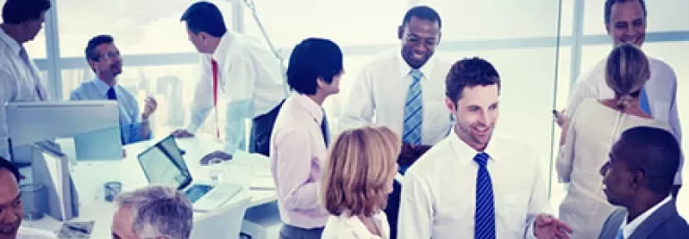Group of professionals having a meeting in an office with large windows.