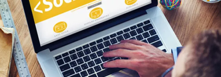 Person using a laptop with a social media screen, coffee nearby.