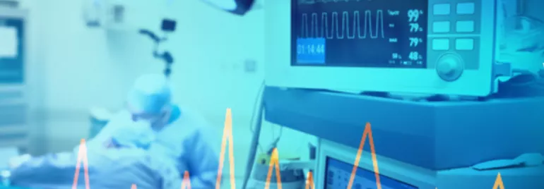 Hospital operating room with patient and heart monitor.