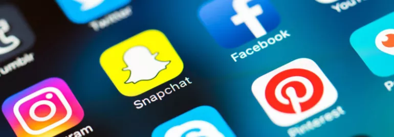 Close-up of various social media app icons on a smartphone screen.