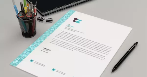 A modern letterhead on a desk with a pen holder and notebook.