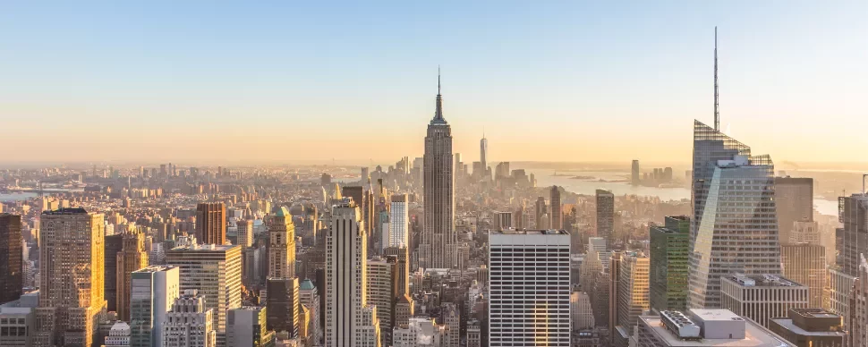 Skyline of New York City at sunset with the Empire State Building in view.
