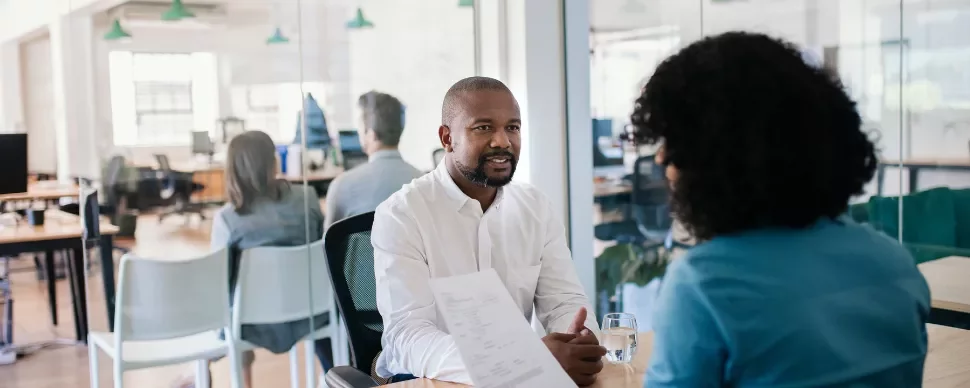 Two people having a conversation in a modern office setting.