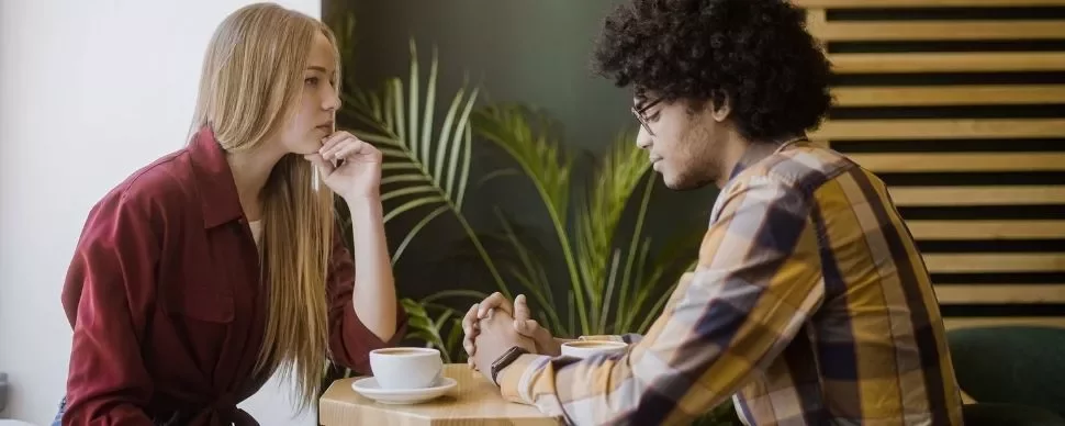 Two people deep in conversation at a cafe table.