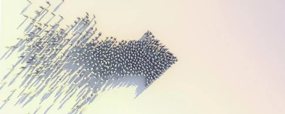 A group of people forming a large arrow on a light background, viewed from above.