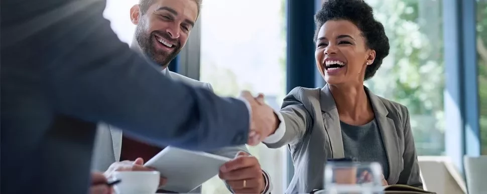 Smiling professionals shaking hands in a bright office