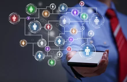 Person holding a smartphone displaying a network of connected icons symbolizing social connectivity.