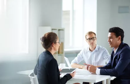 Three business professionals having a meeting in a bright office