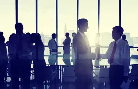 Silhouettes of business people interacting in a modern office setting.