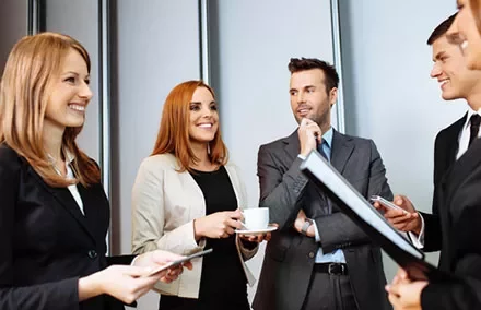 Group of business professionals smiling and engaging in a conversation.