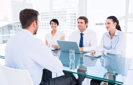 Group interview in modern office with four professionals discussing at a table.