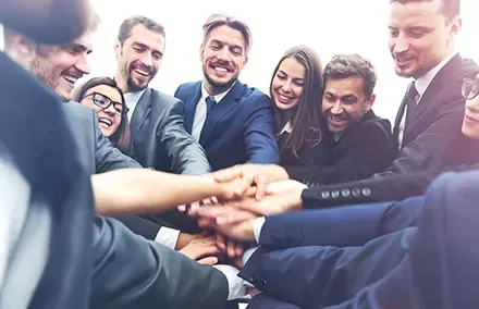 Group of business professionals stacking hands in teamwork.